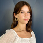 Porträt einer Mitarbeiterin von Freischuetz vor einer bauen Wand