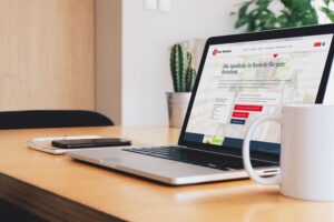 Laptop auf Holztisch zeigt Website der Rats-Apotheke mit Text zu Beratung und Online-Terminvereinbarung